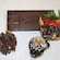 A Graycliff chocolate bar sits next to 3 pieces of chocolate coated confections
